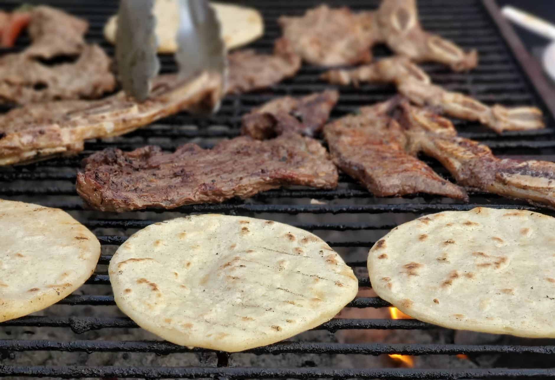 grilled meat and flat bread on black grill