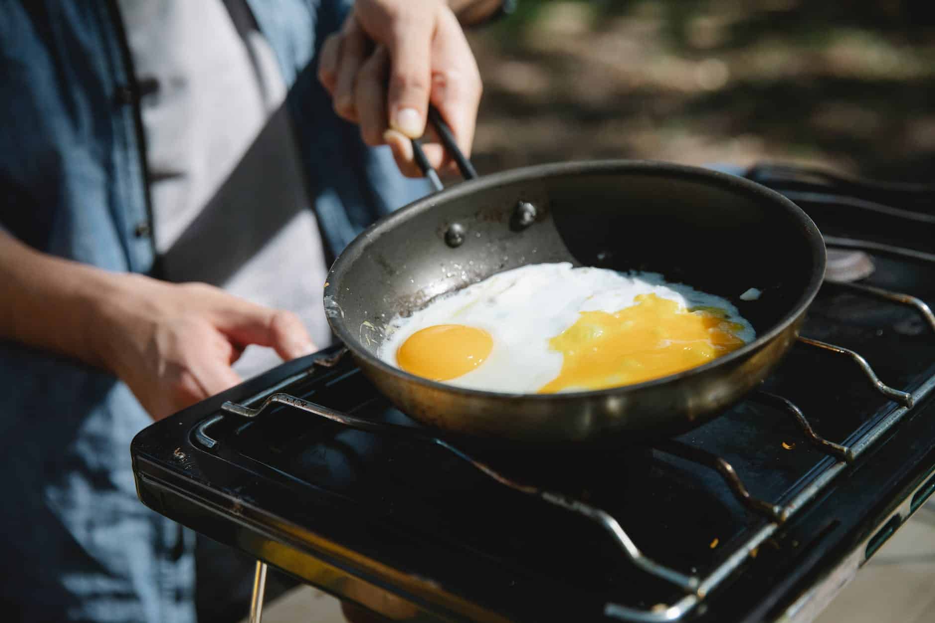 anonymous man frying eggs on skillet